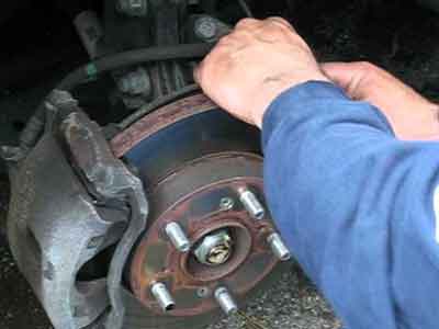 Technician fitting a brake disc and caliper